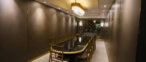 A conference room with a long table, chairs, and a chandelier.