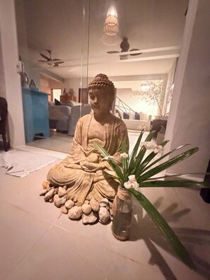 A statue of a seated figure with a vase of flowers beside it.