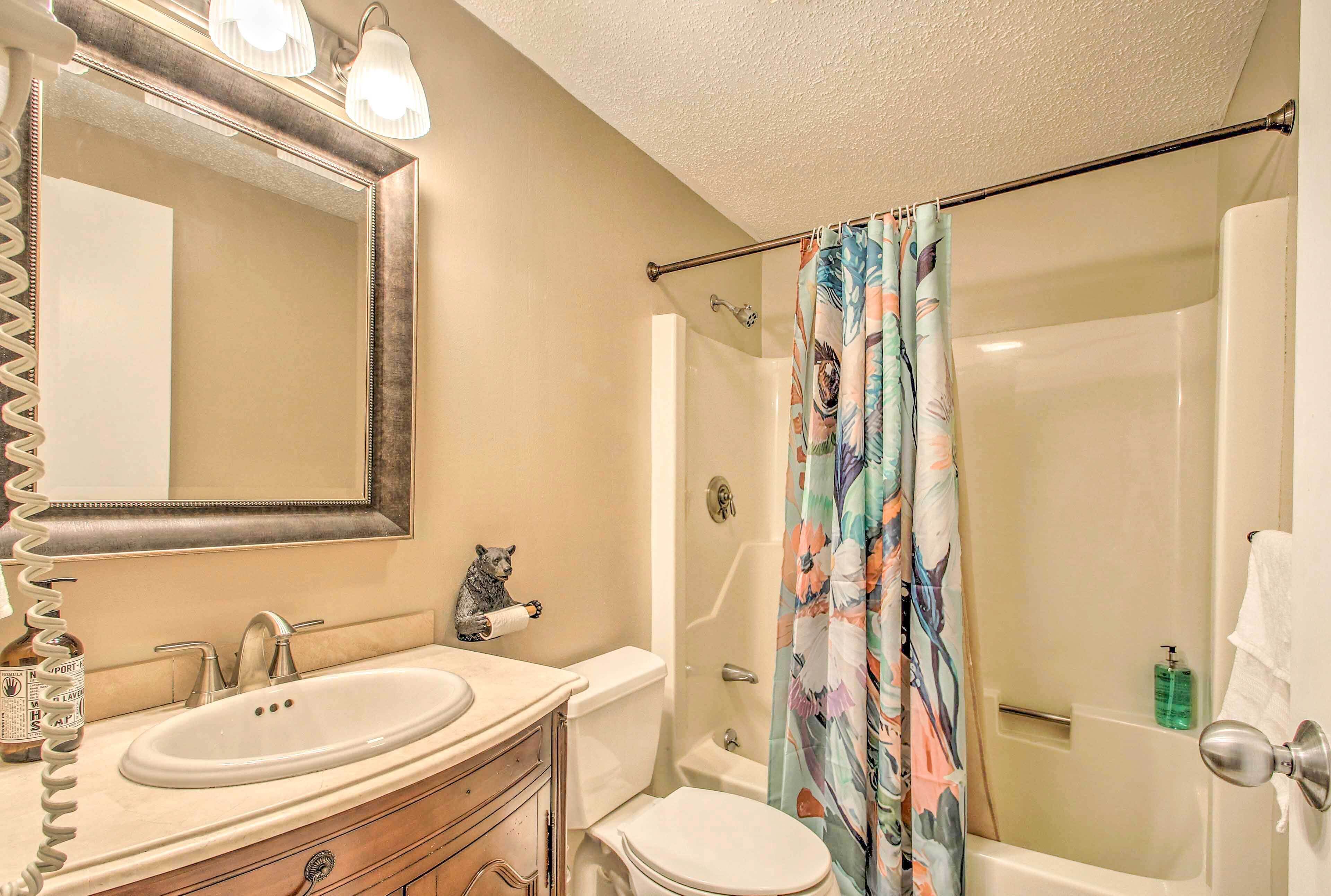 A bathroom with a sink, toilet, and shower.