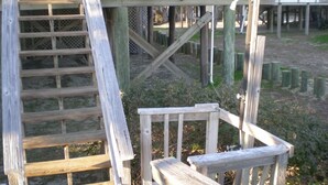 Une terrasse en bois avec une échelle et un banc.