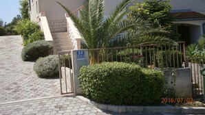 A residential building with a paved entrance, a gate, and a staircase leading to the entrance. - APARTMAN MIKELIN(2+1) AND 2 ROOMS(EACH FOR 2 PEOPLE) (Primošten)