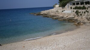 A coastal hotel with a rocky shoreline, clear blue sea, and a pebble beach. - APARTMAN MIKELIN(2+1) AND 2 ROOMS(EACH FOR 2 PEOPLE) (Primošten)