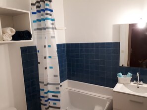 Bathtub, hair dryer, towels, toilet paper