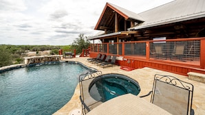 A swimming pool with a wooden deck, lounge chairs, and a covered area with a red railing. - Perfect for Families! Big Patio, Pool/Hot Tub (Burnet)