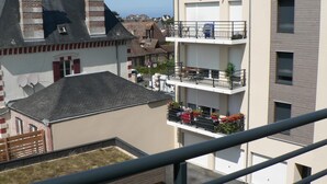 Un edificio de varios pisos con balcones, un garaje y vista al mar.