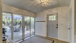 Quarto com porta de correr de vidro que dá para um pátio externo, porta com olho mágico e luminária no teto.