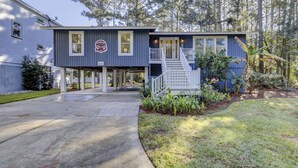 A two-story house with a covered porch, a satellite dish, and a sign that reads "Coastal Home Down." - Sunset Rentals | Bradley Circle 9 | Dog Friendly (Hilton Head Island)