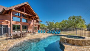 A log cabin with a swimming pool and outdoor seating.