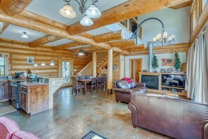 Interior espacioso de una cabaña de madera con cocina, comedor y sala de estar.