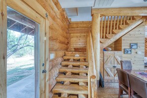 Una escalera de madera que lleva a una habitación con vistas a árboles.