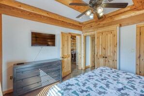 Un dormitorio con cama, cómoda y ventilador de techo.