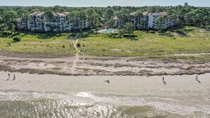 A coastal hotel with multiple buildings, a sandy beach, and a swimming pool. - Sunset Rentals | Beachside Tns 1870 (Hilton Head Island)