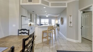 Una cocina amplia con una isla central, sillas de madera y una mesa de comedor.