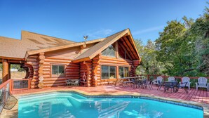 Une cabane en rondins dotée d’une piscine et d’un espace extérieur aménagé pour se détendre.