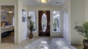 A hallway with a tiled floor, a wooden door with a glass panel, and a ceiling fan. - Sunset Rentals | Baynard Park 6 | Dog Friendly (Hilton Head Island)