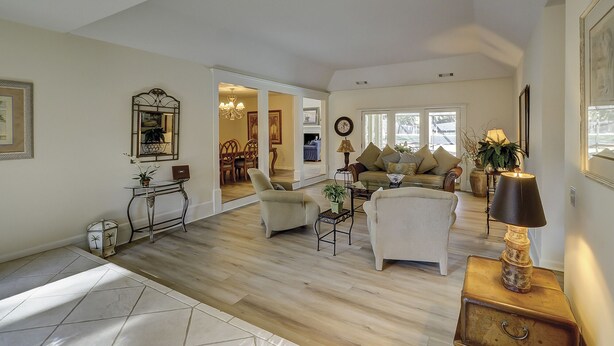 A spacious living room with a sofa, armchairs, and a coffee table. There is a dining area visible through an open doorway. - Sunset Rentals | Baynard Park 6 | Dog Friendly (Hilton Head Island)