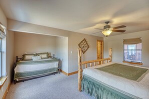Traditional bedroom with two single beds, a ceiling fan, and a window with an outside view.