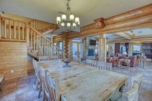 Cozy living area with a fireplace, dining table, and staircase.