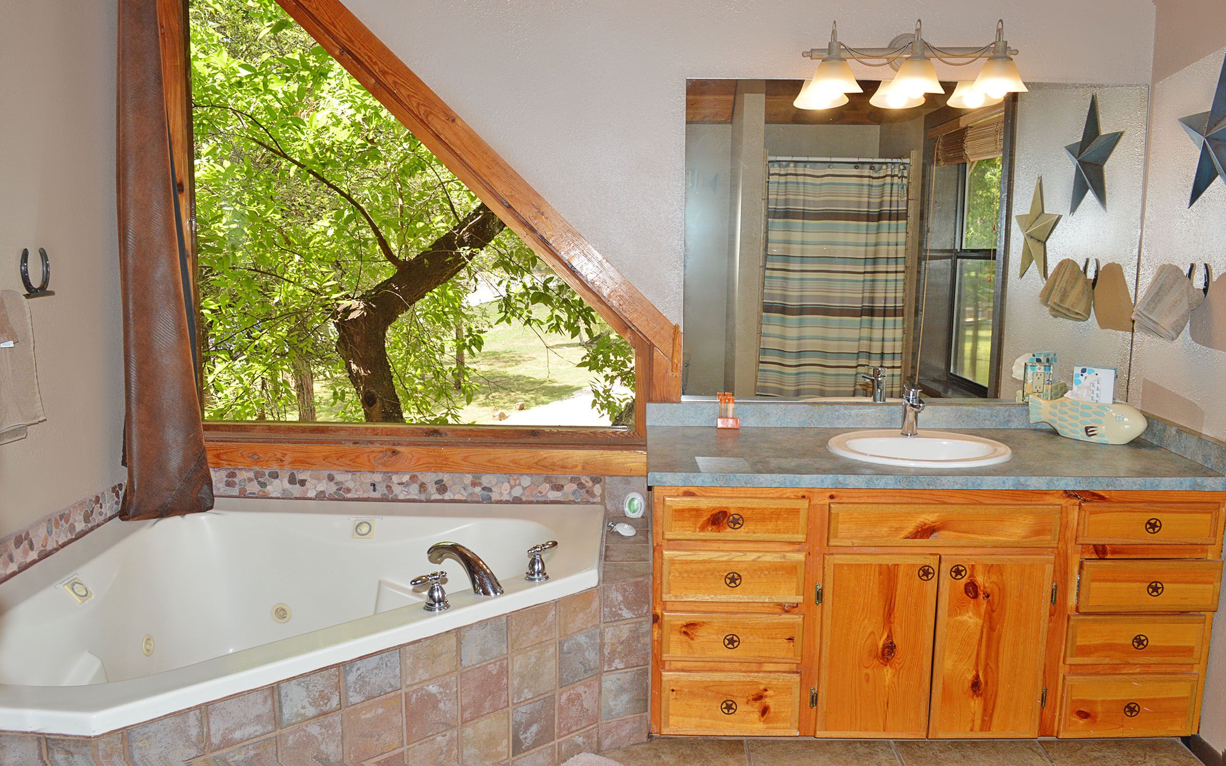 A bathroom with a bathtub, wooden cabinets, a sink, and a large mirror.