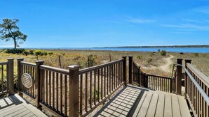 A wooden deck leading to a beach with a clear view of the water. - Sunset Rentals | Beachside Tns 1869 (Hilton Head)