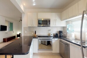 Enjoy cooking in this well-lit kitchen with an oven, microwave, and compact coffee maker.