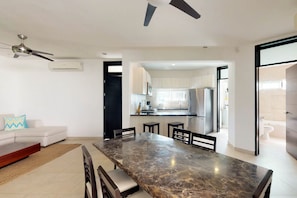 Enjoy a spacious living area with a dining table and comfortable seating, a well-equipped kitchen with a large island.