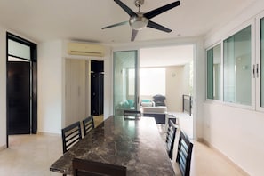 Enjoy meals in this spacious dining area with a large table and cabinet, offering a seamless transition to the adjacent outdoor space.