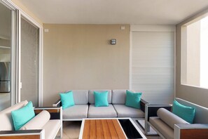 Relax in a light-filled living area with a comfortable sofa and armchairs, perfect for unwinding.