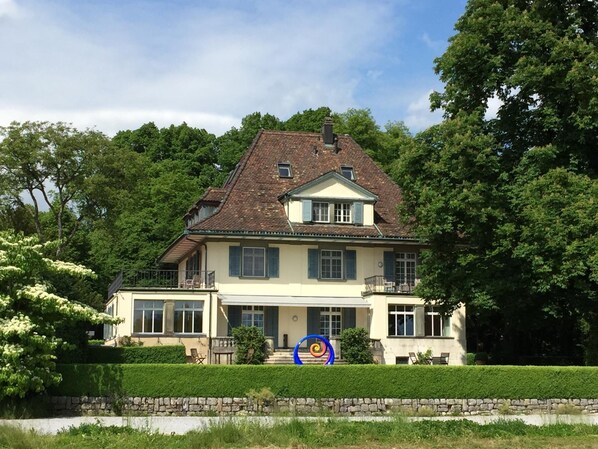 A two-story house with a symmetrical facade, a central entrance, and a small balcony.