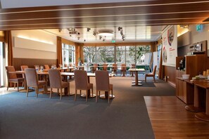 A conference room with a long table, chairs, and a whiteboard.
