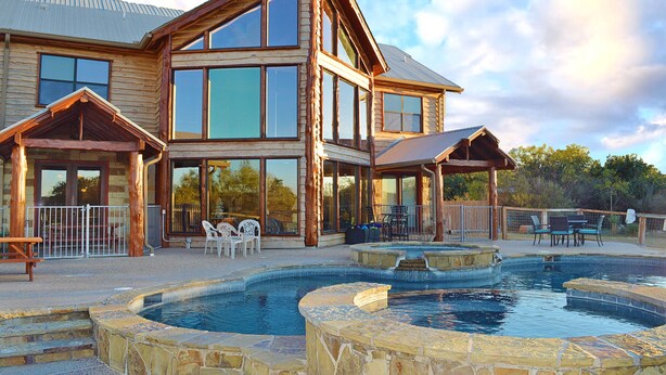 A large wooden house with a swimming pool and outdoor seating. - Spacious 5BR Retreat w/ Pool, Hot Tub & Game Room (Burnet)