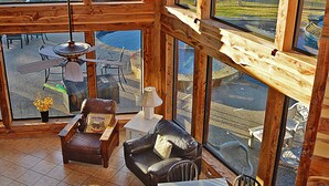 A spacious room with large windows, a ceiling fan, and a view of the outdoors. - Spacious 5BR Retreat w/ Pool, Hot Tub & Game Room (Burnet)