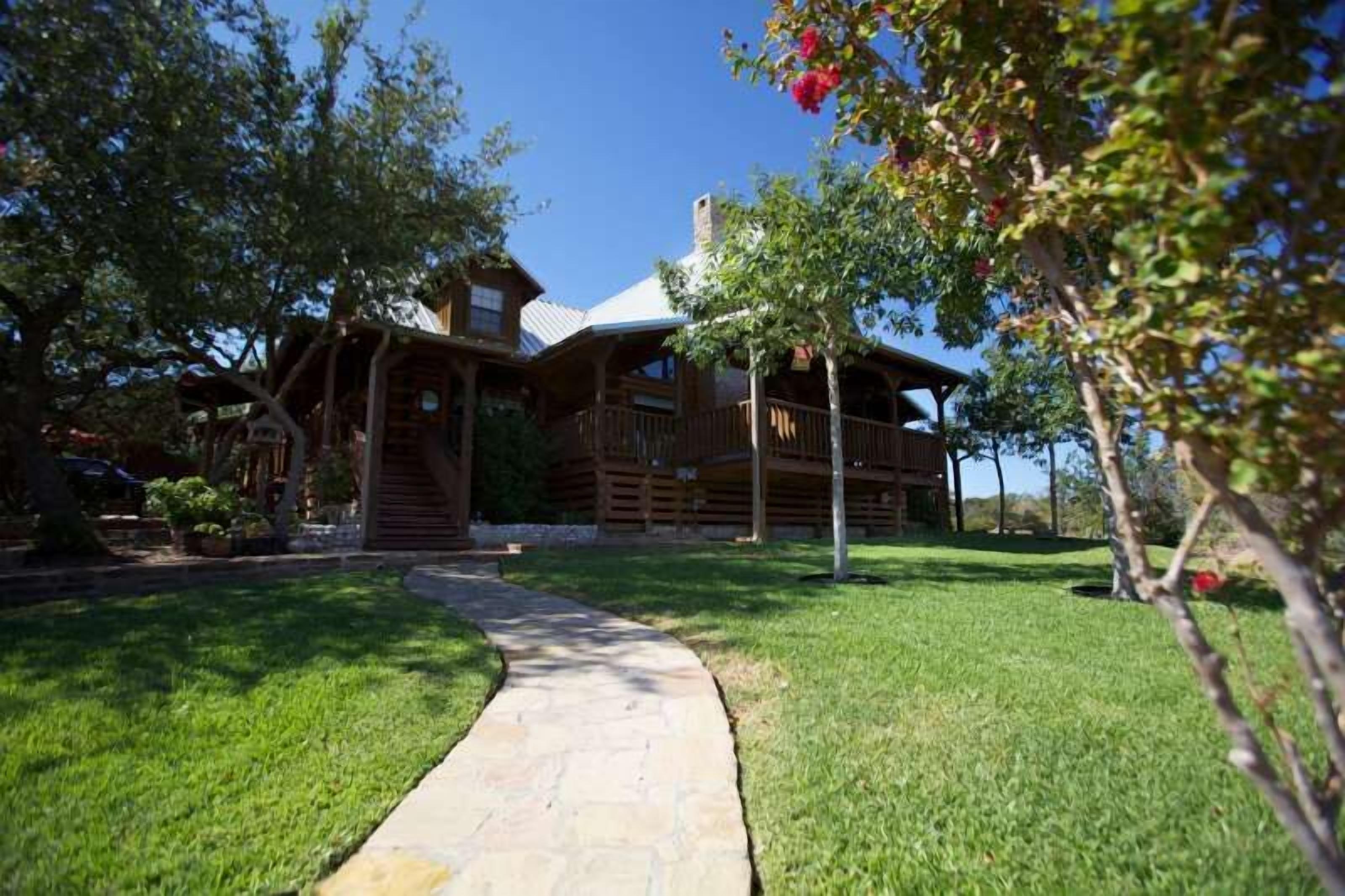 A log cabin with a stone pathway leading to the entrance.