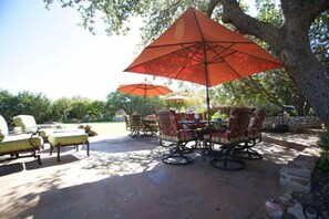 Enjoy dining al fresco under the shade of two large umbrellas in this outdoor patio area.