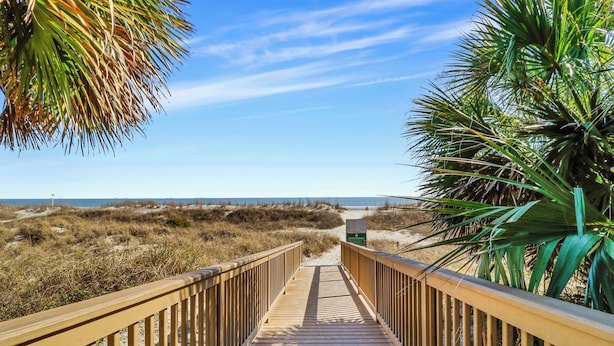 A wooden boardwalk leading to a beach with a clear sky. - Sunset Rentals | Captains Walk 416 (Hilton Head)