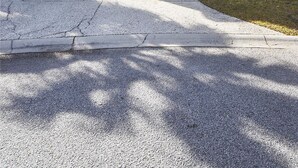 A two-story house with a garage, a driveway, and a tree in the front yard. - Sunset Rentals | Crabline 49 | Dog Friendly (Hilton Head Island)