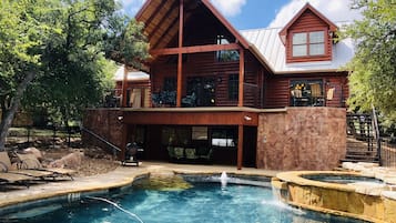 A log cabin with a pool and outdoor seating.