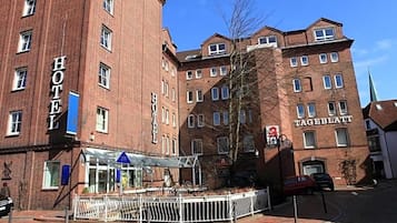 Ein Hotel mit einem gut sichtbaren 'HOTEL'-Schild, einem überdachten Eingang und einer Ziegel-Fassade.