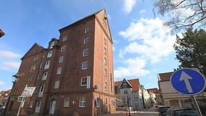 Un hotel de varios pisos con una torre destacada, cielo despejado y una señal de indicaciones.