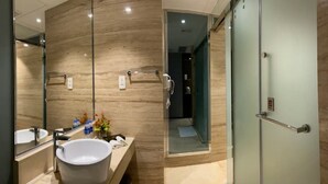Een moderne badkamer met een grote wastafel, spiegel en een douchecabine van glas.