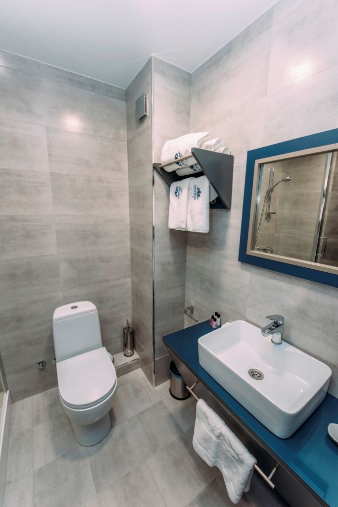 A modern bathroom with a toilet, sink, and shower.