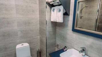 A modern bathroom with a toilet, sink, and shower.