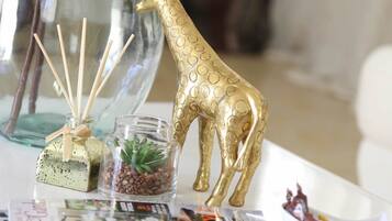 A table with a decorative glass vase, a golden giraffe figurine, a small glass terrarium, and a bowl of candy.