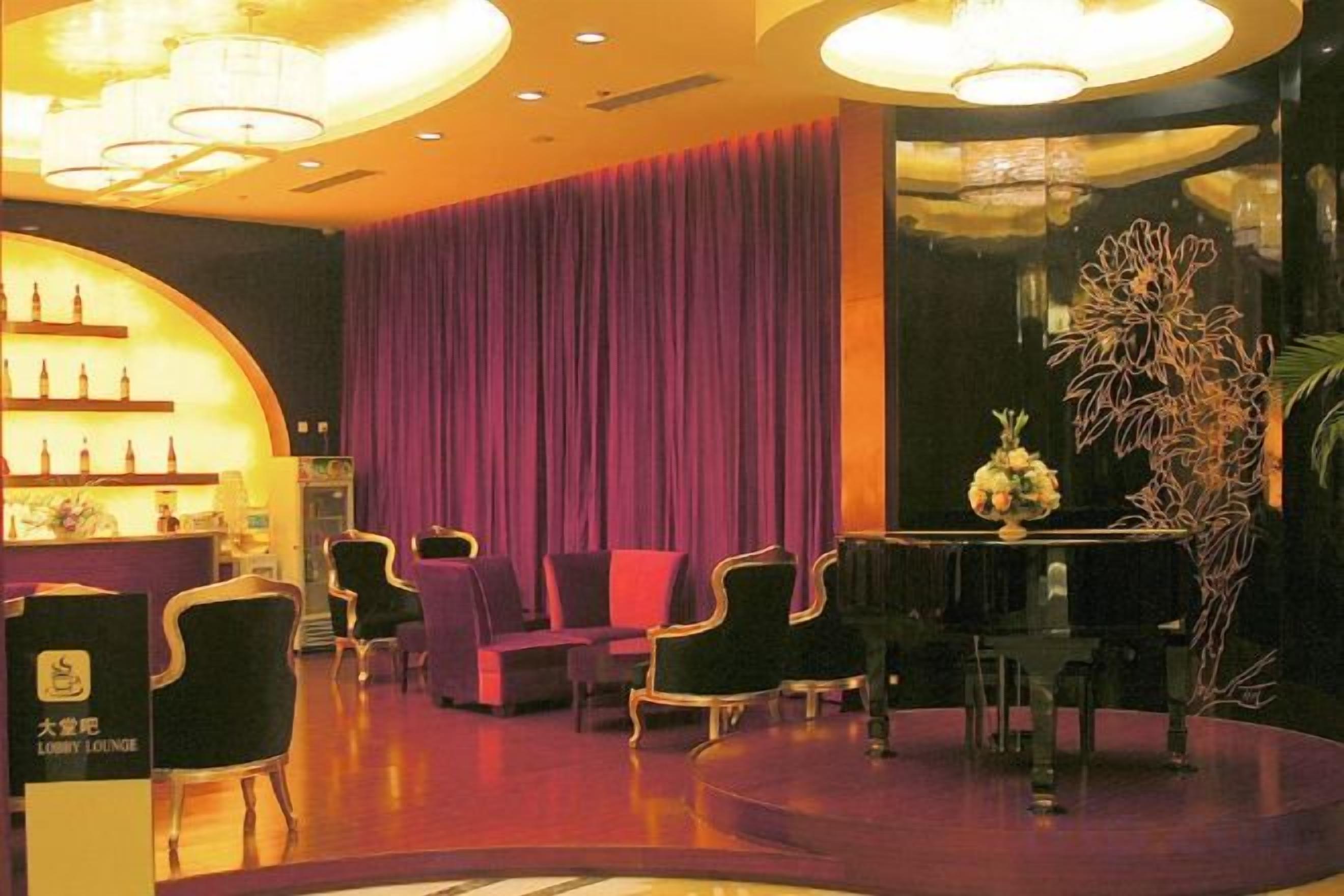 A lobby with a reception desk, seating area, and a decorative plant.