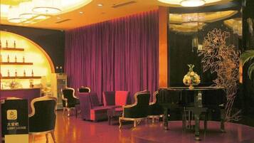 A lobby with a reception desk, seating area, and a decorative plant.