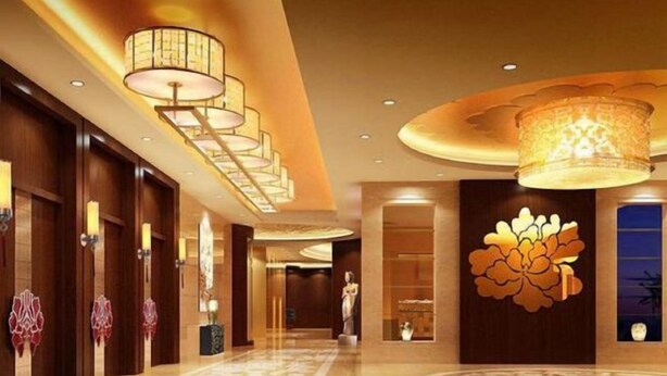 A hotel lobby with a grand chandelier, a large floral wall decoration, and a polished marble floor. - Oceanwide Hotel (Weifang)