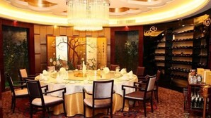 A formal dining room with a round table set for six, surrounded by chairs. - Oceanwide Hotel (Weifang)
