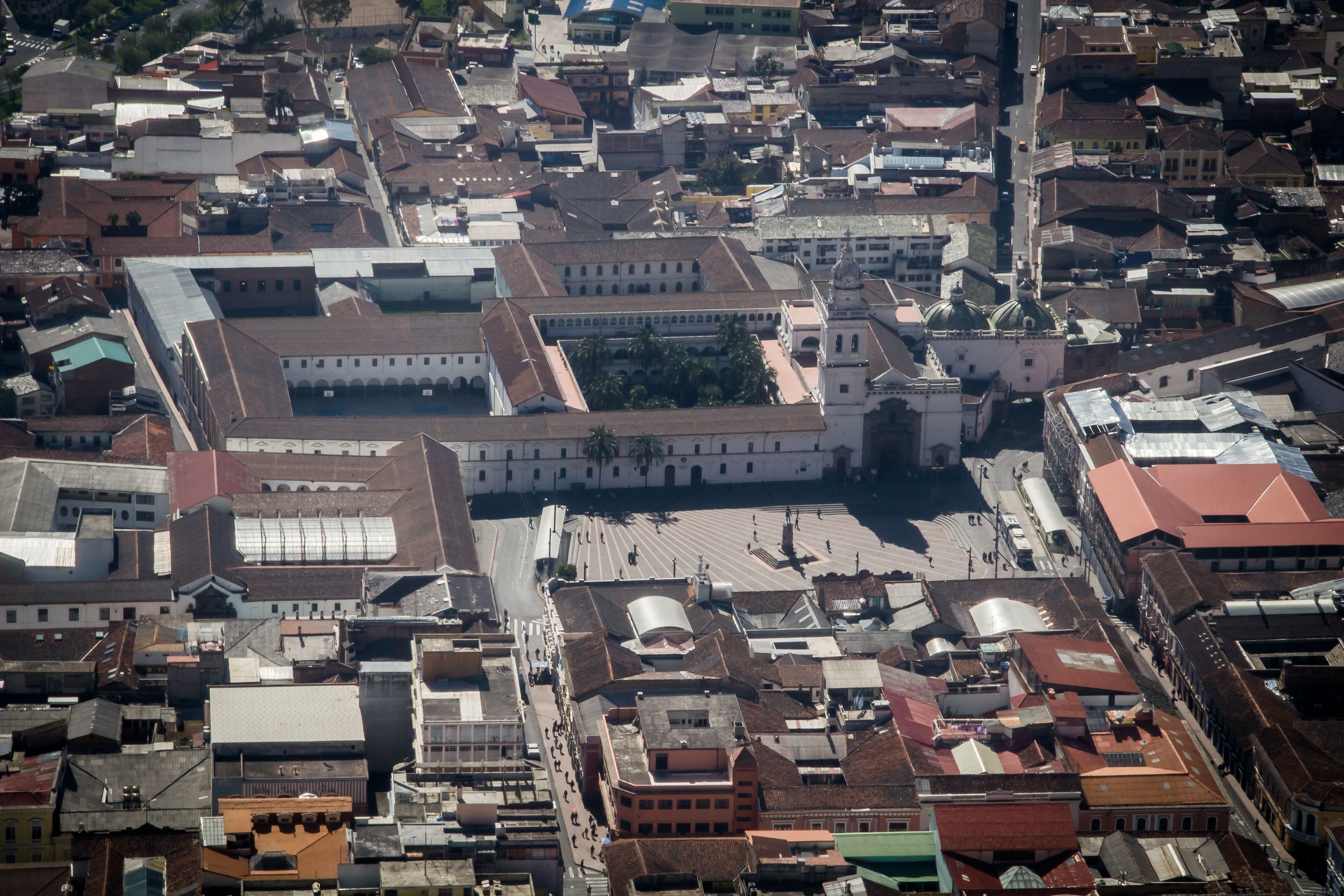 Eine Vogelperspektive auf ein historisches Stadtzentrum mit dichter Bebauung, darunter ein markantes Gebäude mit einer Kuppel und ein großer, offener Platz.