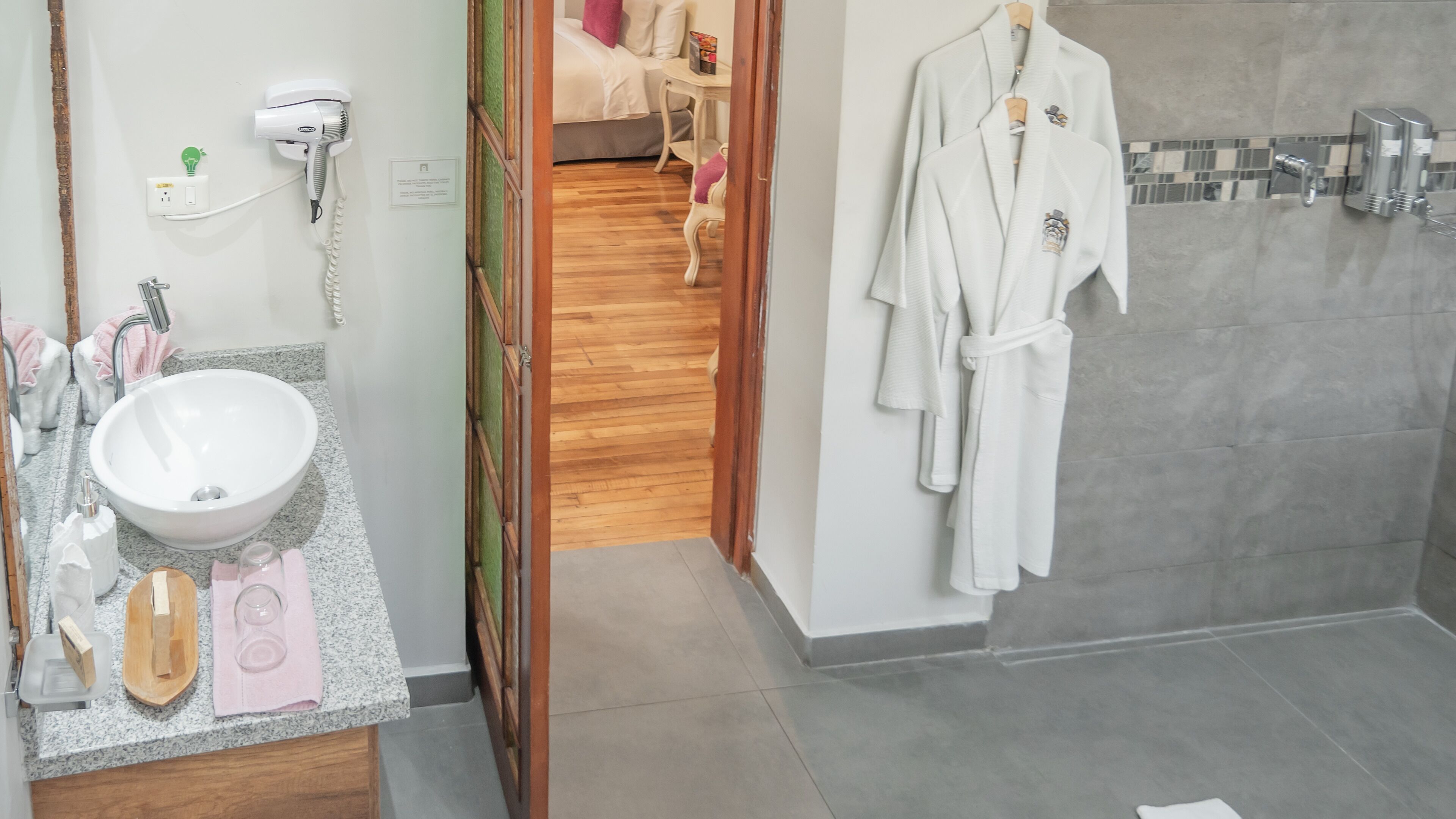 Une salle de bain avec un lavabo, un porte-serviettes et un peignoir accroché au mur.