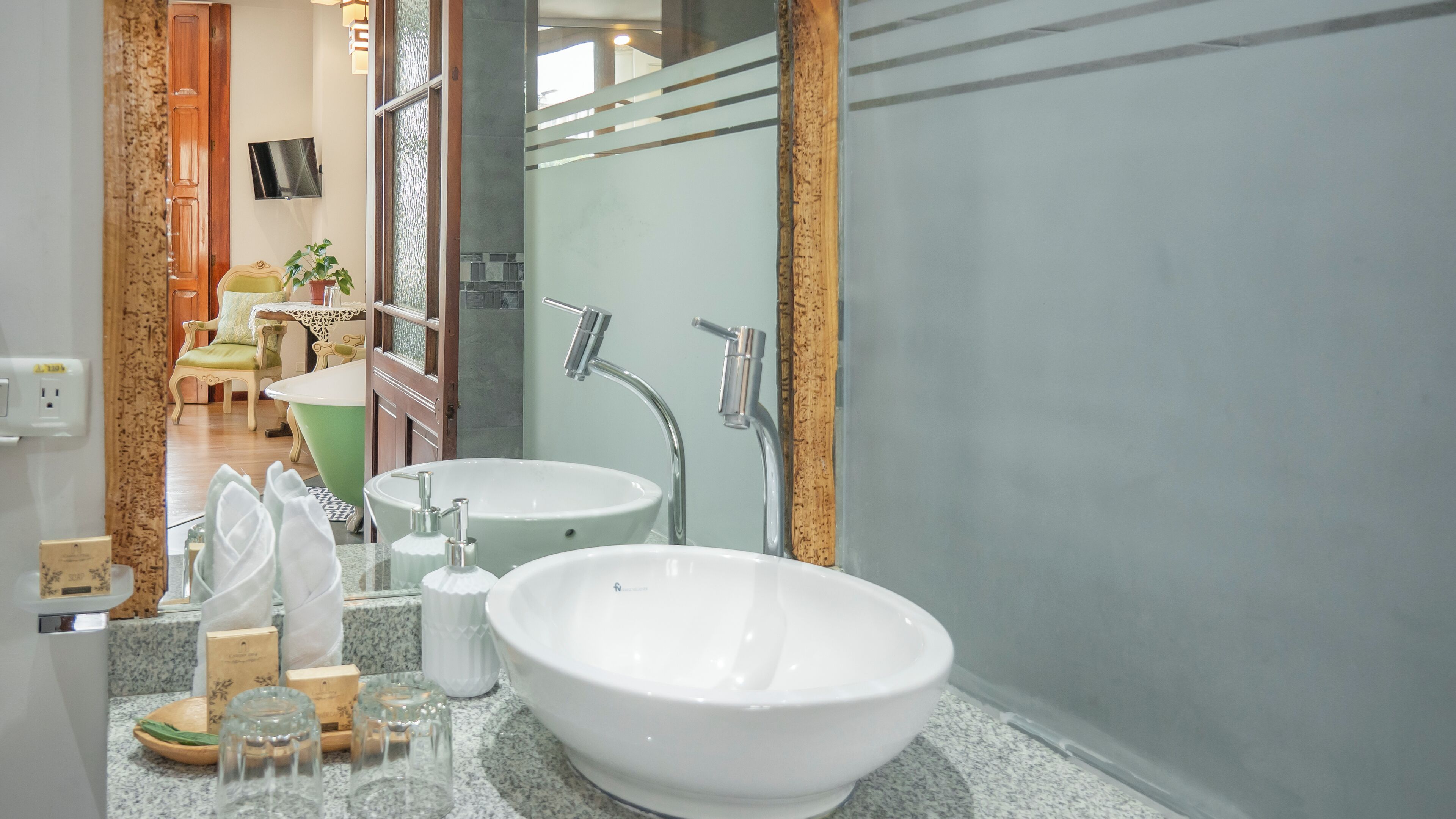 A bathroom with two sinks, a mirror, and a shower.